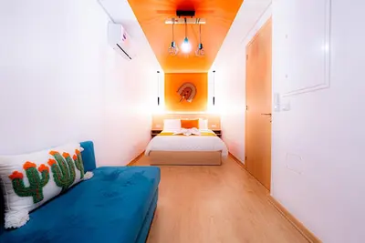 a bedroom with a blue couch and a bed at M REVASION Appt 3 chambres , front de lac , piscine chauffée privée in Marrakech