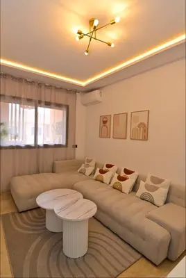a living room with a large couch and a table at Appartement neuf et moderne Marrakech in Marrakech