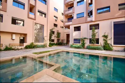 a swimming pool in front of a building at Appartement neuf et moderne Marrakech in Marrakech