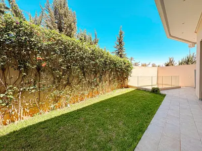 a hedge in front of a house with a lawn at Villa Leonardo in Marrakech