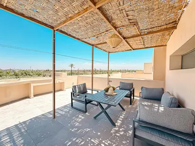 a patio with a table and chairs on a roof at Villa Leonardo in Marrakech