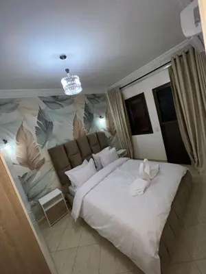 a bedroom with a large bed with a painting on the wall at votre parfait sejour in Marrakech