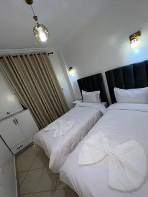 two beds in a hotel room with white sheets at votre parfait sejour in Marrakech