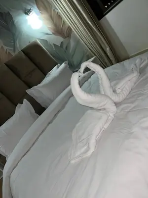 a bed with white sheets and towels on it at votre parfait sejour in Marrakech