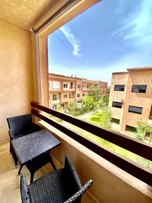 a balcony with two chairs and a table and a window at Lux appartement avec piscine in Marrakech