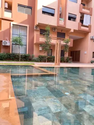 a building with a swimming pool in front of a building at Lux appartement avec piscine in Marrakech