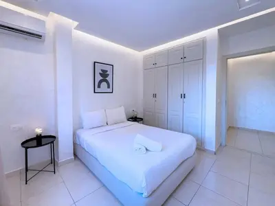 a white bedroom with a large white bed in it at Appart Confort et raffinement au cœur de Marrakech in Marrakech