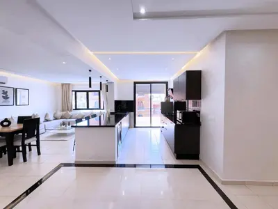 a living room with a kitchen and a dining room at Appart Confort et raffinement au cœur de Marrakech in Marrakech
