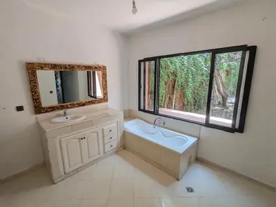 a bathroom with a tub and a sink and a mirror at Oasis Villa in Marrakech
