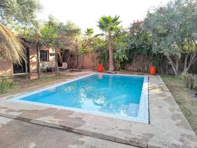 a swimming pool in the yard of a house at Oasis Villa in Marrakech