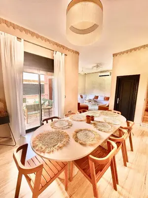 a dining room with a table and chairs at Superbe villa 3 chambres proche du centre-ville avec piscine privée in Marrakech