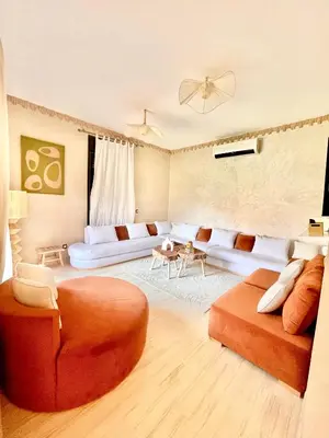 a living room with a couch and a table at Superbe villa 3 chambres proche du centre-ville avec piscine privée in Marrakech