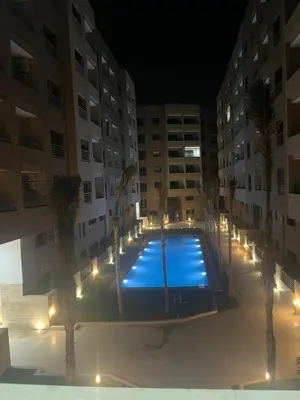 a large swimming pool with palm trees in front of a building at Leila in Marrakech