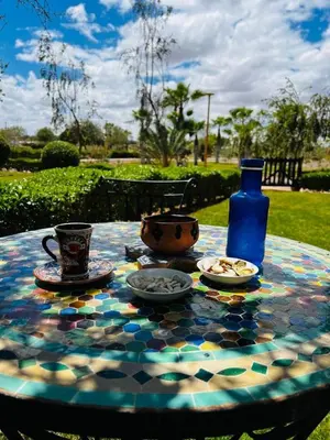 a table with plates and cups and a blue bottle at Almaz appartement in Marrakech