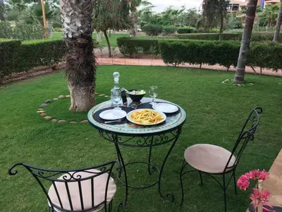 a table and chairs with a plate of pasta on it at Almaz appartement in Marrakech