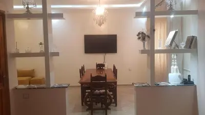 a living room with a table and a flat screen tv at Home for peace & enjoyment in Marrakech