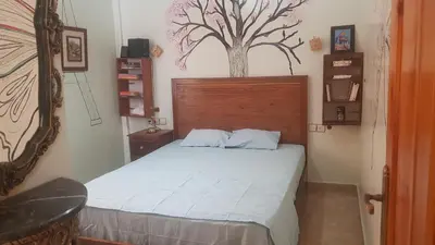 a bedroom with a bed with a tree on the wall at Home for peace & enjoyment in Marrakech