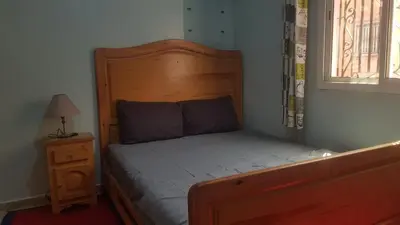 a bed with a wooden headboard in a bedroom at Home for peace & enjoyment in Marrakech