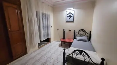 a bedroom with a bed and a bench and a door at Comfortable room, balcony in Marrakech