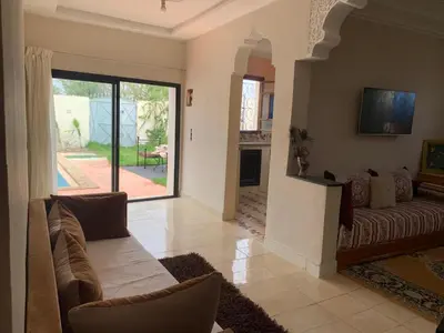 a living room with a couch and a tv at paradis in Aït Bou Setta