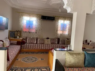 a living room with a couch and two windows at paradis in Aït Bou Setta