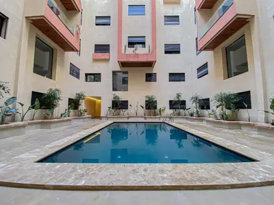 a swimming pool in front of a building at Laube Hivernage in Marrakech