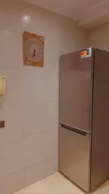 a refrigerator in a room with a clock on the wall at Appartement Majorella Gueliz Centre Marrakech in Marrakech