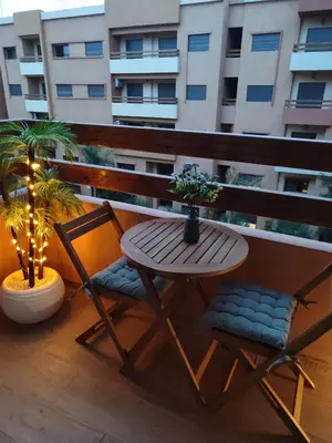 a table and chairs on a balcony with a building at Ochre City apartment Balcony, Pool, Fiber Optic, Free Parking - Family ONLY in Marrakech