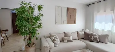 a living room with a couch and two plants at Ochre City apartment Balcony, Pool, Fiber Optic, Free Parking - Family ONLY in Marrakech
