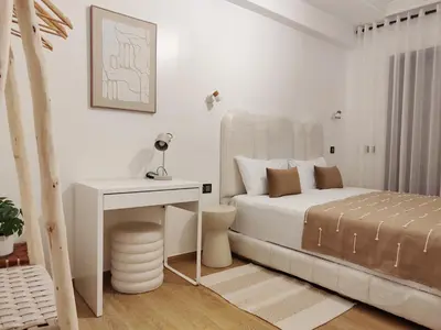 a white bedroom with a bed and a desk at Ochre City apartment Balcony, Pool, Fiber Optic, Free Parking - Family ONLY in Marrakech
