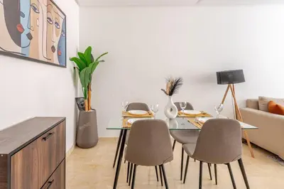 a dining room with a table and chairs and a couch at Urban Comfort - Pool - Netflix IPTV Parking in Marrakech
