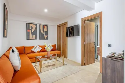 a living room with an orange couch and a table at Urban Comfort - Pool - Netflix IPTV Parking in Marrakech