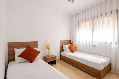 a bedroom with two beds and a window at Urban Comfort - Pool - Netflix IPTV Parking in Marrakech