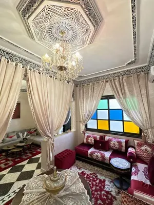 a living room with a couch and a chandelier at Riad apartment Beldi style in Marrakech