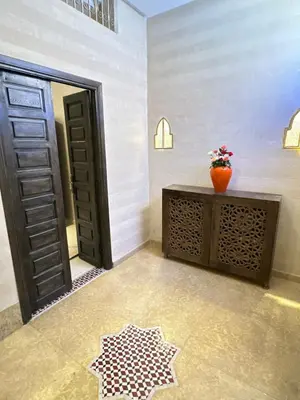a room with a door and a vase on a table at Riad apartment Beldi style in Marrakech