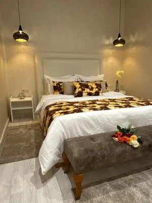 a bedroom with a large bed and a table at Riad apartment Beldi style in Marrakech