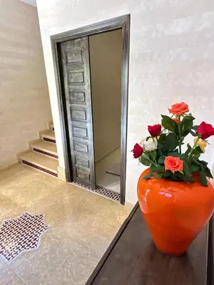an orange vase with flowers in front of a mirror at Riad apartment Beldi style in Marrakech