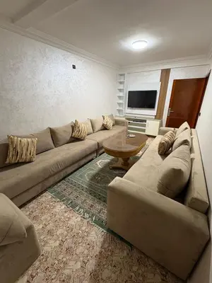 a living room with a couch and a table at Appartement cosy avec 2 terrasses in Marrakech
