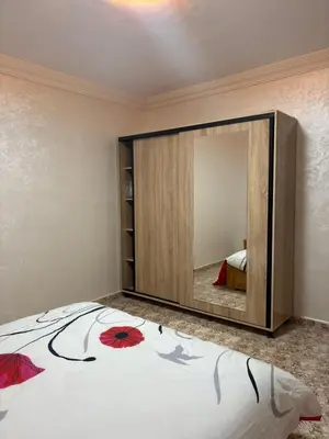 a bedroom with a large mirror on the wall at Appartement cosy avec 2 terrasses in Marrakech