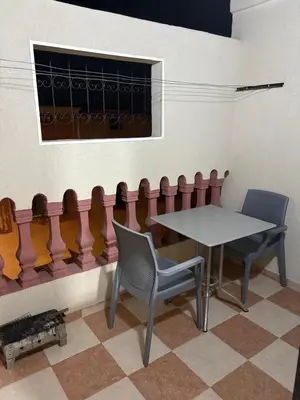 a table and chairs in a room with a window at Appartement cosy avec 2 terrasses in Marrakech