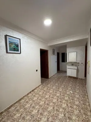 an empty room with white walls and a painting on the wall at Appartement cosy avec 2 terrasses in Marrakech