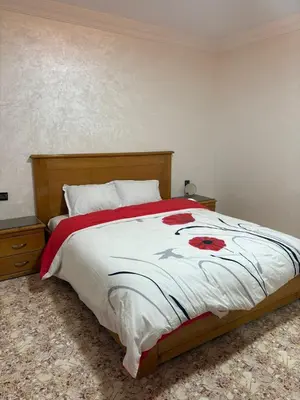 a bedroom with a bed with a red flower on it at Appartement cosy avec 2 terrasses in Marrakech