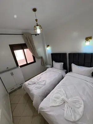 two beds sitting next to each other in a room at Appartement de luxe 15 mn du centre in Marrakech
