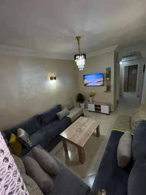 a living room with a blue couch and a table at Appartement de luxe 15 mn du centre in Marrakech