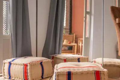 three ottoman chairs sitting in a room at Appartement yasmina in Marrakech