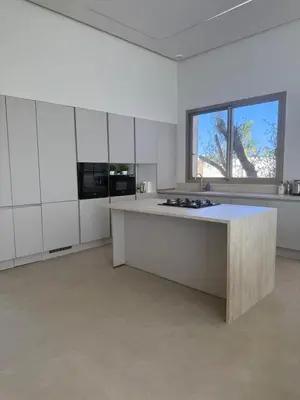 a large kitchen with white cabinets and a large island at Villa Zeytoune sans vis à vis in Marrakech