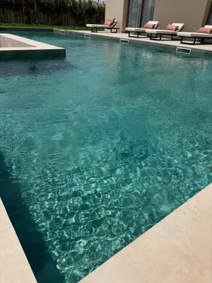 a swimming pool with blue water in a building at Villa Zeytoune sans vis à vis in Marrakech