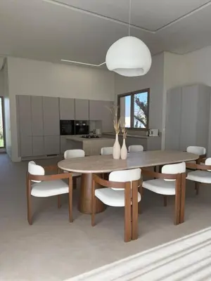 a dining room with a wooden table and white chairs at Villa Zeytoune sans vis à vis in Marrakech