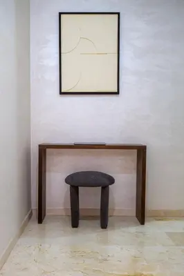 a stool in front of a wall with a picture at Heart of Marrakech - Hivernage 2 bedroom apartment in Marrakech