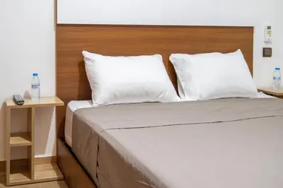 a bed with white pillows and a wooden headboard at Heart of Marrakech - Hivernage 2 bedroom apartment in Marrakech